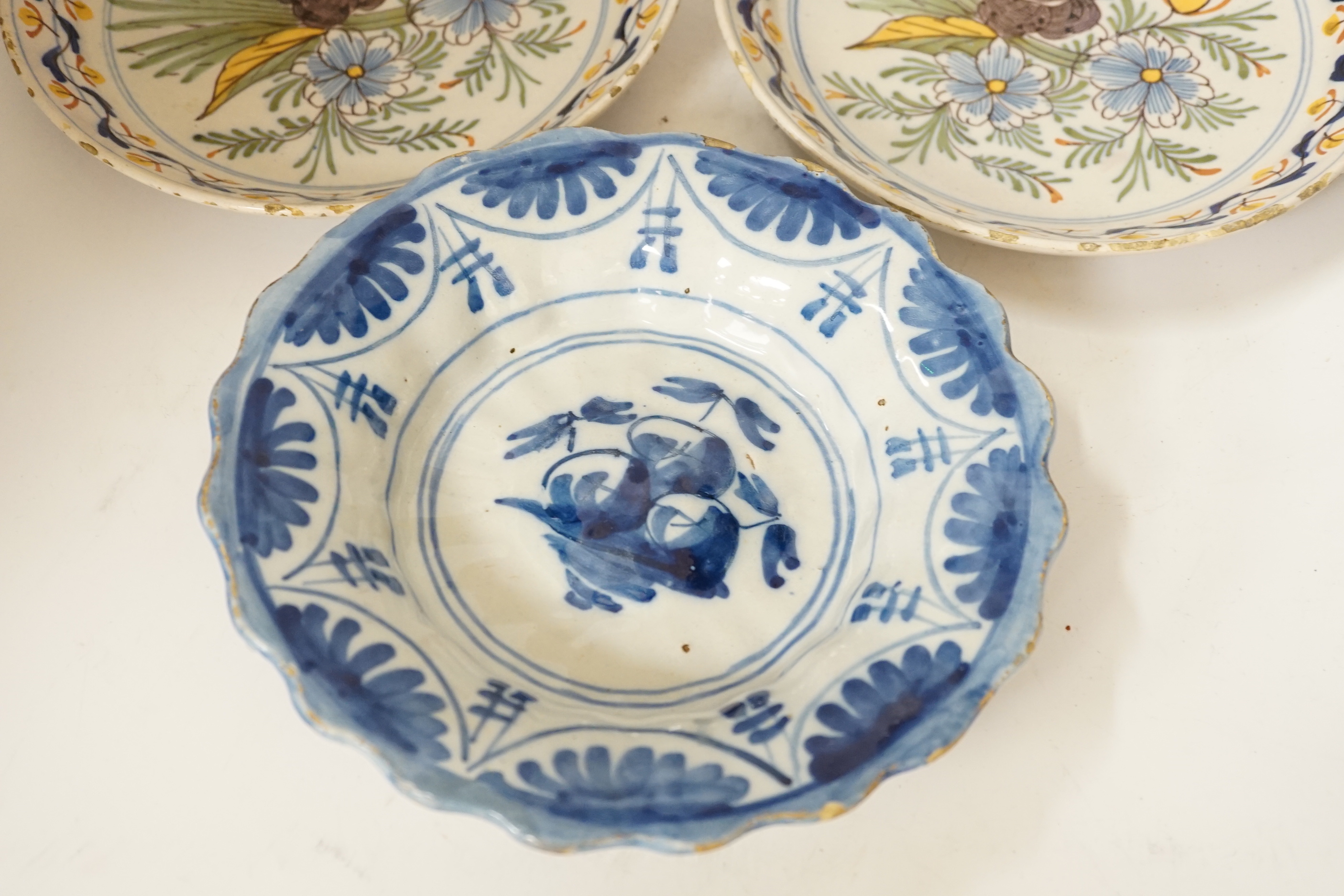 A Delft blue and white dish, c.1700 and two 18th century Delft polychrome dishes, 22cm (3)